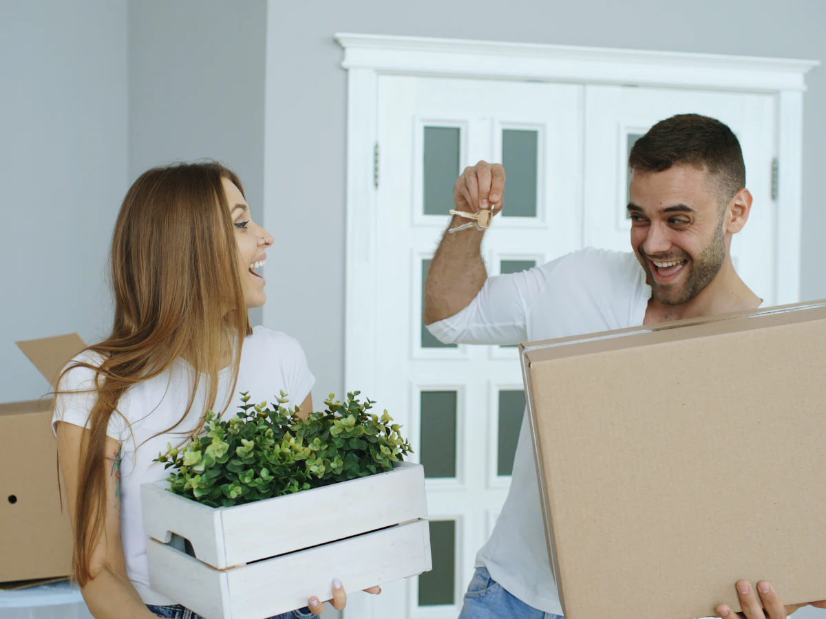 Couple carrying moving boxes into their new home