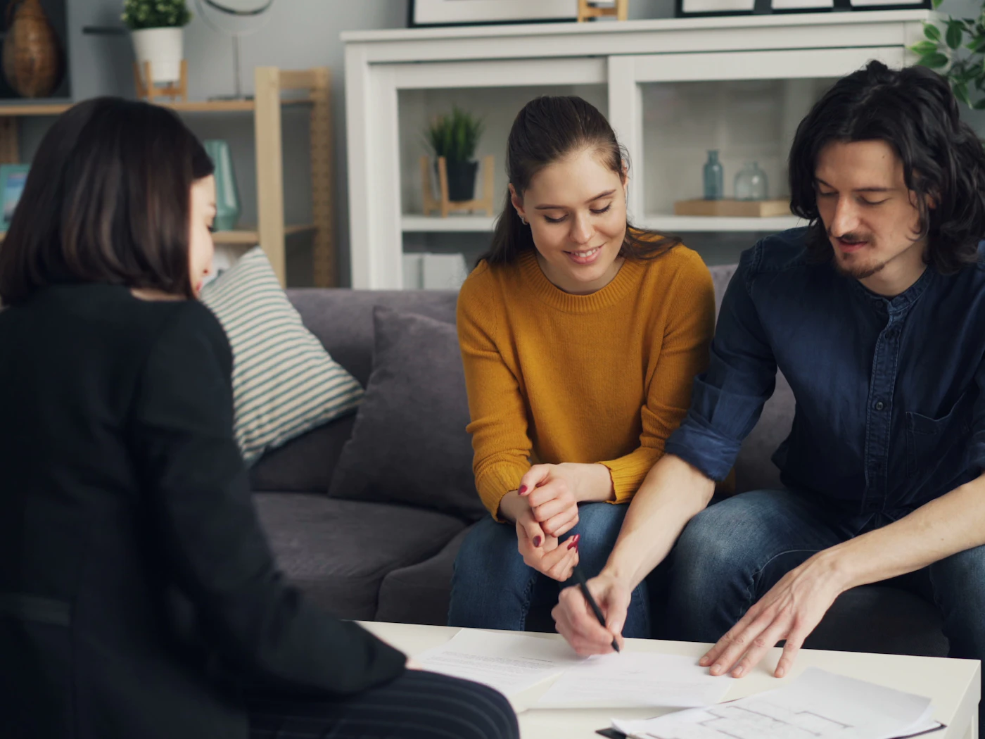 Signing agent going over loan documents with a couple at their home