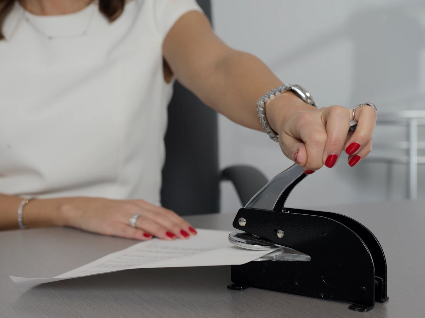 Notary pressing an embosser seal onto a signed document