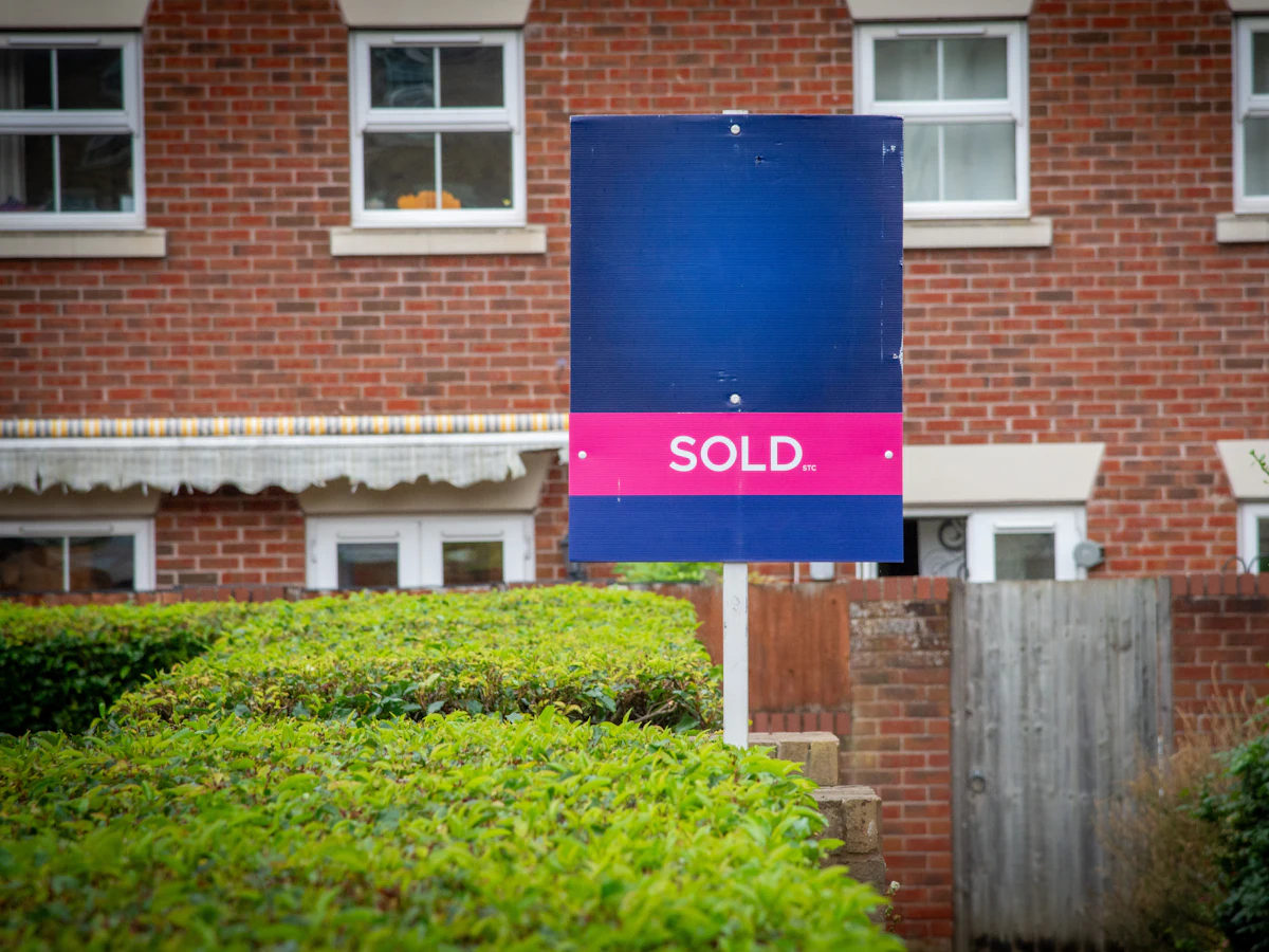 Sold sign in front of a brick house