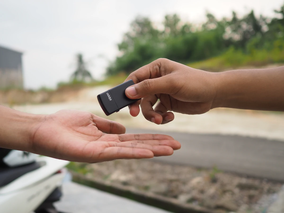 Car key being handed from one person to another